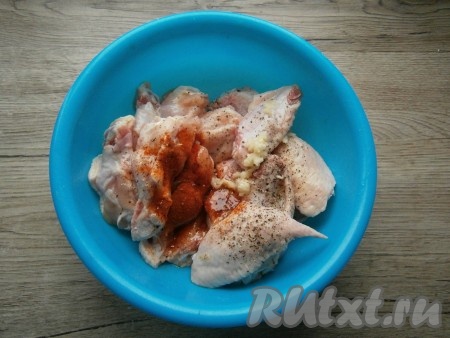 Смешать крылья с паприкой, пропущенным через пресс чесноком, солью, смесью перцев и растительным маслом.
