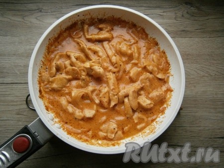 Сковороду накрыть крышкой, убавить огонь до минимального и тушить курицу около 10 минут.