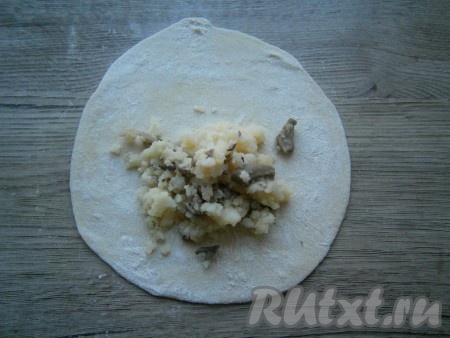 Затем тесто обмять, разделить на небольшие кусочки. На припыленном мукой столе раскатать каждый кусочек теста в тонкую лепешку. На одну сторону каждого раскатанного кусочка теста выложить по 1-2 столовых ложки картофельно-грибной начинки.
