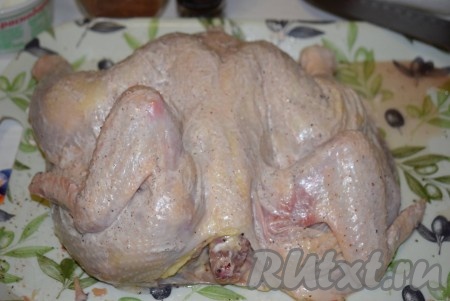 2 зубчика чеснока, пропущенных через пресс, смешиваем с майонезом. Получившейся смесью чеснока и майонеза равномерно смазываем курицу и внутри, и снаружи. Оставляем курицу пропитаться специями и майонезом минимум на 1 час (можно оставить и на более длительное время, но тогда курицу нужно будет убрать в холодильник).