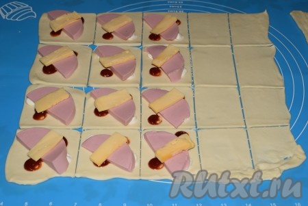 На колбасу выложить твердый сыр, нарезанный на полосы.
