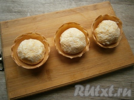 Из сырной массы влажными руками сформировать три комочка-шарика, разместить их в тарталетках.
