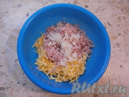 Очищенный и мелко нарезанный репчатый лук добавить в миску к ветчине и сыру.
