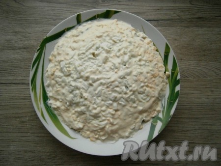 Разделить все яйца на белки и желтки. Белки с двух яиц оставить для украшения, оставшиеся белки и желтки натереть на терке и выложить следующим слоем в салат, смазать майонезом.
