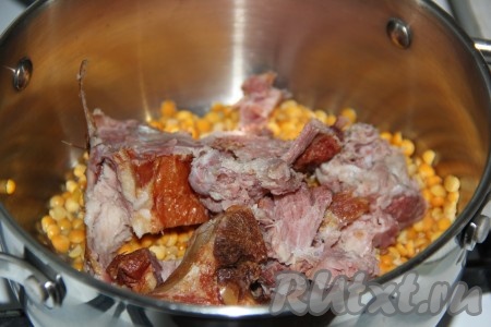 Горох, предварительно хорошо промытый под проточной водой, выложить в кастрюлю. Рёбрышки разрезать на кусочки и тоже выложить в кастрюлю.
