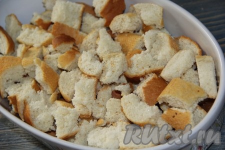 Батон разломать на крупные кусочки и выложить в форму на карамель.