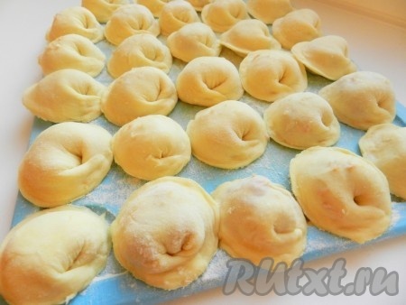 Разделочную доску посыпать мукой, выкладывать на неё сформированные домашние пельмени (как на фото) в один слой. Поставить в морозилку для замораживания и приступить к лепке следующей партии пельменей, постепенно используя всё тесто. Замороженные пельмени можно переложить в целлофановый пакет для дальнейшего хранения. Часть свежеслепленных пельменей можно сварить сразу.