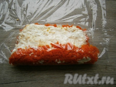 Затем аккуратно, начиная со стороны, на которую выложена рыба, помогая себе пищевой пленкой, свернуть поплотнее в рулет.
