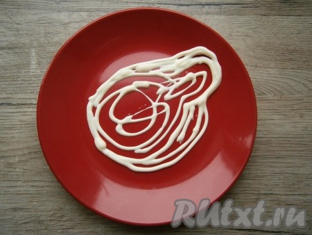 На плоской тарелке майонезом (или сметаной) с помощью кулинарного мешка с отверстием нарисовать очертание головы свинки Пеппы.
