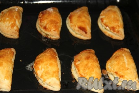 Выпекать пирожки с начинкой из яйца, сыра, зелени и лука в разогретой духовке при температуре 190 градусов, примерно, 25 минут. Сверху они должны стать золотистого цвета.
