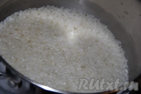 Поставить кастрюлю на средний огонь и варить рис до полного испарения воды (примерно, 7-10 минут с момента закипания).
