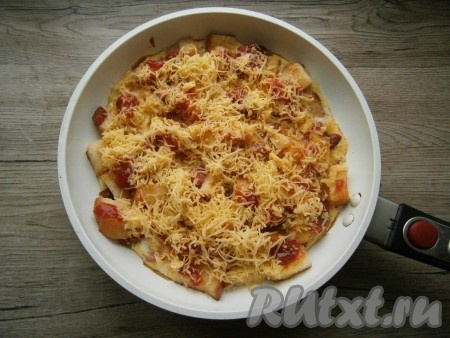 Далее накрыть сковороду крышкой и жарить пиццу из хлеба на слабом огне еще около 3-4 минут, после чего посыпать щедро тертым сыром. Снова накрыть сковороду крышкой и выдержать пиццу на слабом огне 1-1,5 минуты.
