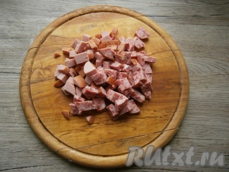 Чуть меньшими кубиками нарезать сосиски и колбасу.
