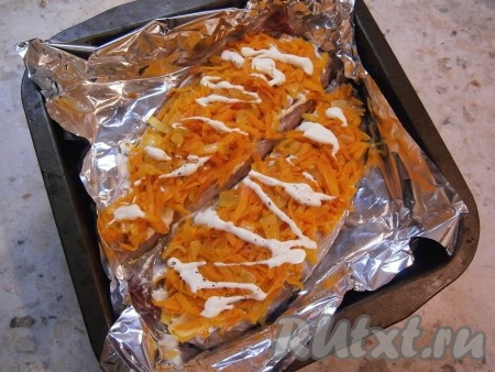 Выложить обжаренные лук и морковь на половинки скумбрии, сверху еще чуть смазать майонезом (или сметаной), немного посыпать специями и солью.
