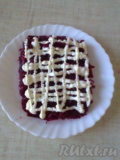 Собрать салат "Подарочек", смазывая каждый слой майонезом.
Для 1 слоя используем половину натертой свеклы, выкладываем на тарелку в виде прямоугольника, смазываем майонезом.