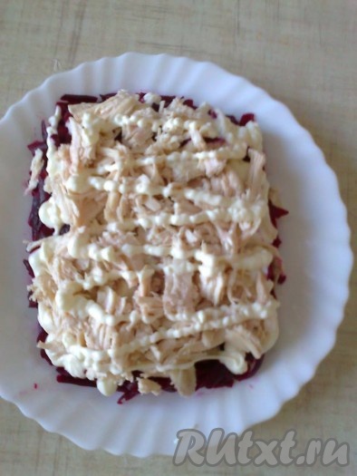 Для 2 слоя используем половину отварного филе, хорошо смазываем майонезом.