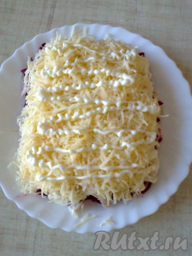 Для 3 слоя используем половину натертого сыра, хорошо смазываем майонезом.