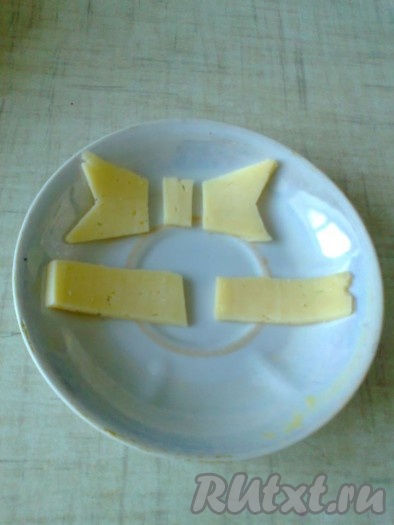 Из сыра сначала вырезать украшения - бантик и полосочки.