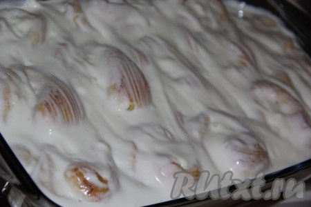 Для приготовления заливки соединить сметану с сахаром и перемешать. Достать булочки с творогом из духовки. Выложить сметанную заливку поверх булочек.&nbsp;
