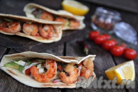 В каждую порцию вложить по три креветки поверх овощной начинки. Сразу подать тако с начинкой из креветок и овощей к столу. Очень вкусно, сочно и аппетитно!
