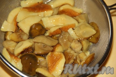 Маринованные грибы откинуть на дуршлаг и дать стечь маринаду. Если грибы крупные, тогда их нужно разрезать на 2 или 4 части. Мелко нарезать грибы не нужно, в салате должны быть чётко видны все ингредиенты.
