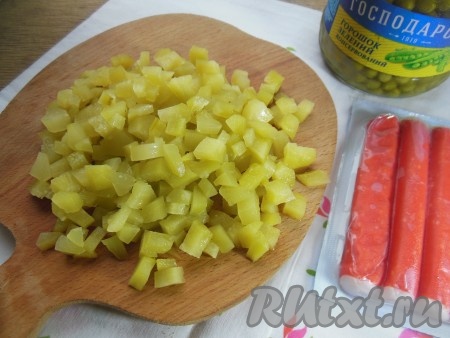 Огурцы тоже нарежьте на мелкие кубики. Лучше, если в салате "Оливье" все ингредиенты будут нарезаны на кубики, примерно, одинакового размера.
