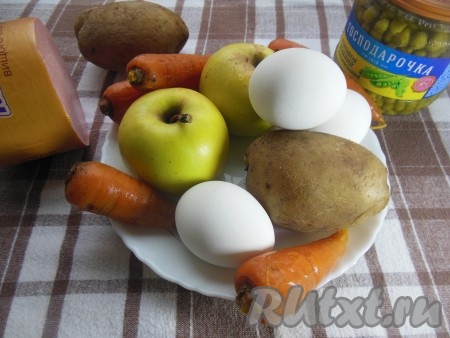 Подготовьте продукты для приготовления "Оливье" с яблоком и колбасой. Куриные яйца залейте холодной водой и варите минут 8-10 с момента закипания воды, затем остудите и очистите от скорлупы. Картошку и морковь вымойте и, не очищая от кожуры, залейте полностью водой, отправьте на огонь и отварите до готовности в течение минут 30-35 (готовые овощи будут легко прокалываться вилкой), затем остудите и очистите.  
