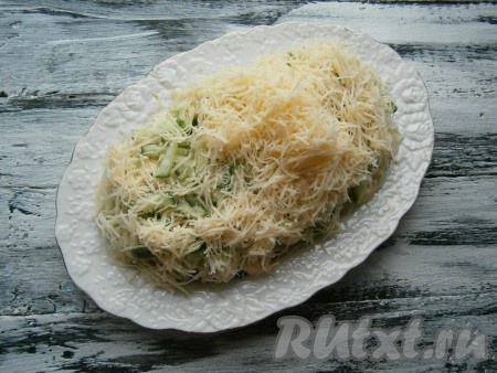 Свежий огурец нарезать тоненькой соломкой (часть огурчика оставить для украшения) и выложить его на картофель. Далее идёт слой натёртого на мелкой тёрке сыра.