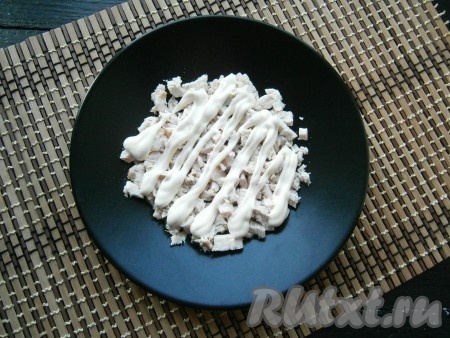 Куриное филе, предварительно отваренное в подсоленной воде в течение 25-35 минут, остудить, а затем нарезать его кусочками и выложить первым слоем на тарелку, смазать майонезом.
