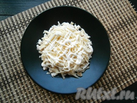 Половину сыра натереть на крупной терке и выложить его следующим слоем, только не придавливать, чтобы получилась горка, смазать майонезом.
