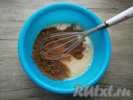 Хорошенько взбить венчиком получившуюся массу, всыпать просеянный какао-порошок и разрыхлитель. Перемешать венчиком до однородного состояния.
