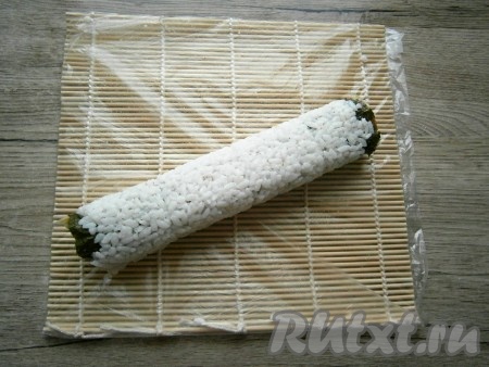 С помощью циновки свернуть все в один плотный ролл, начиная от края с авокадо.
