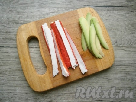 Крабовые палочки нарезать на полоски в длину.
