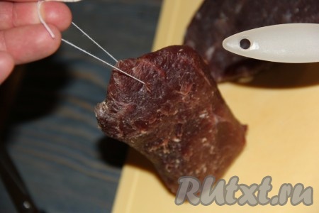 Каждый кусок говядины проткнуть толстой иглой и пропустить толстую нитку (как на фото). Держа мясо за верёвочку, удобно смазывать его смесью специй. Затем за верёвочку можно подвесить мясо на пару часов, для того чтобы специи слегка подсохли (я не подвешивала мясо в специях). Можно этот этап с ниткой просто пропустить.
