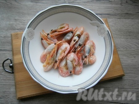 Довести воду до кипения, огонь сделать минимальным. Варить креветки на медленном огне около 5 минут, после чего выложить их в миску и остудить.
