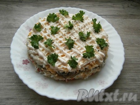 Сверху салат покрыть сеточкой из плавленного сливочного сыра (у меня сливочный сыр "Янтарь"), поместив его в кондитерский мешок и обрезав кончик. Или покрыть салат натертым на терке плавленным сырком. Немного поперчить салат сверху и украсить зеленью петрушки или укропа.
