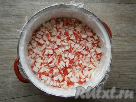 После этого идёт слой мелко нарезанных крабовых палочек, их также немного смазать майонезом.
