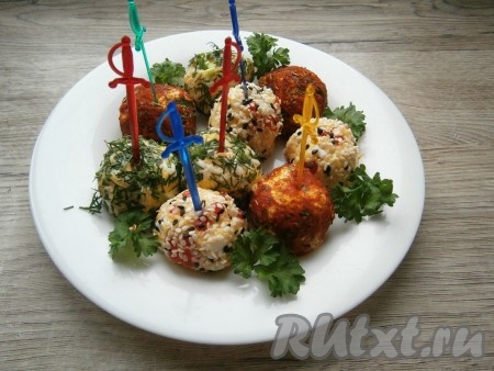 Далее яркие сырные шарики разместить на одной большой тарелке или подать каждому порционно на небольших тарелочках. Можно закуску подавать на шпажках, можно - без них.
