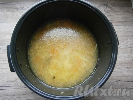 Через 40 минут открыть крышку мультиварки, суп посолить по вкусу, всыпать лапшу, добавить лавровый лист, порошок карри (по желанию, он придаст более яркий цвет нашему куриному супу) и нарезанный очищенный чеснок, закрыть крышку мультиварки. Готовить суп далее до сигнала.