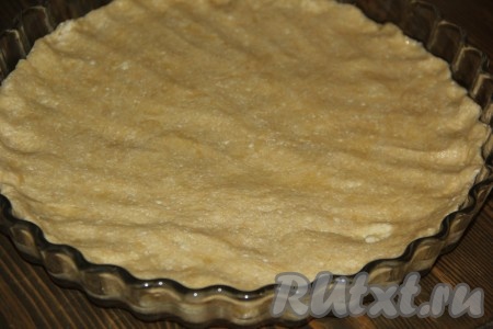 1/3 часть теста, завернув в пакет, нужно убрать в морозильную камеру. Остальное тесто выложить в форму (я выпекала пирог в стеклянной форме диаметром 26 см), разровнять.
