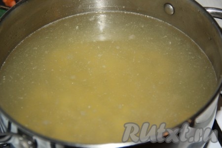 Процеженный бульон поставить на огонь и довести до кипения. Две очищенные картофелины нарезать на кубики и добавить в кипящий бульон, варить 10 минут на небольшом огне.
