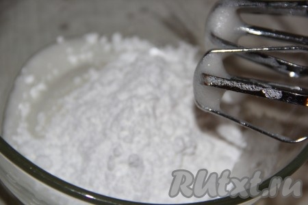 Затем, добавляя понемногу сахарную пудру, взбивать на низкой скорости миксера до стойких пиков. В конце постепенно, не переставая взбивать, влить крутой кипяток и взбивать в течение 1 минуты.
