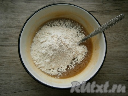 Дать смеси остыть до теплого состояния, периодически перемешивая ее венчиком, затем всыпать муку.
