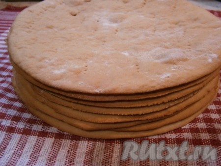 Перед выпечкой разделить тесто на 8-10 частей. Каждую часть теста раскатать на присыпанной мукой поверхности, выпекать корж на противне, застеленном пергаментом. Пока будете раскатывать и выпекать один корж, остальное тесто должно находиться в холоде.