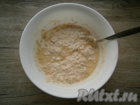 Влить в получившуюся смесь теплую воду, перемешать. Далее добавить растительное масло и также, ложкой, вмешать его в тесто.
