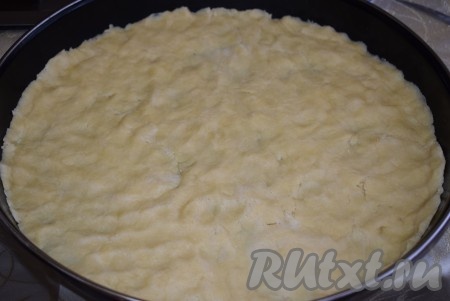 Пока начинка остывает, достаем наше охлажденное тесто. В форму, застеленную пергаментом (или фольгой), выкладываем тесто и равномерно распределяем его, формируя небольшие бортики. 