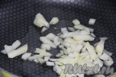 В сковороду влить немного растительного масла, выложить мелко нарезанный лук и, не забывая иногда помешивать, обжарить до золотистого цвета.
