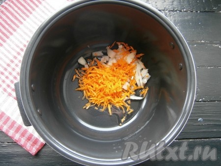 Морковь, чеснок и лук очистить. Лук, нарезанный небольшими кусочками, и морковку, натертую на крупной терке, выложить в чашу мультиварки, влить растительное масло.
