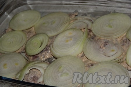 Лук очистить, нарезать тонкими кольцами и выложить поверх мяса.
