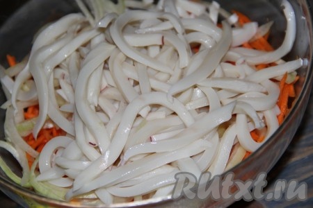 Кальмары нарезать на длинные полоски и добавить к овощам.